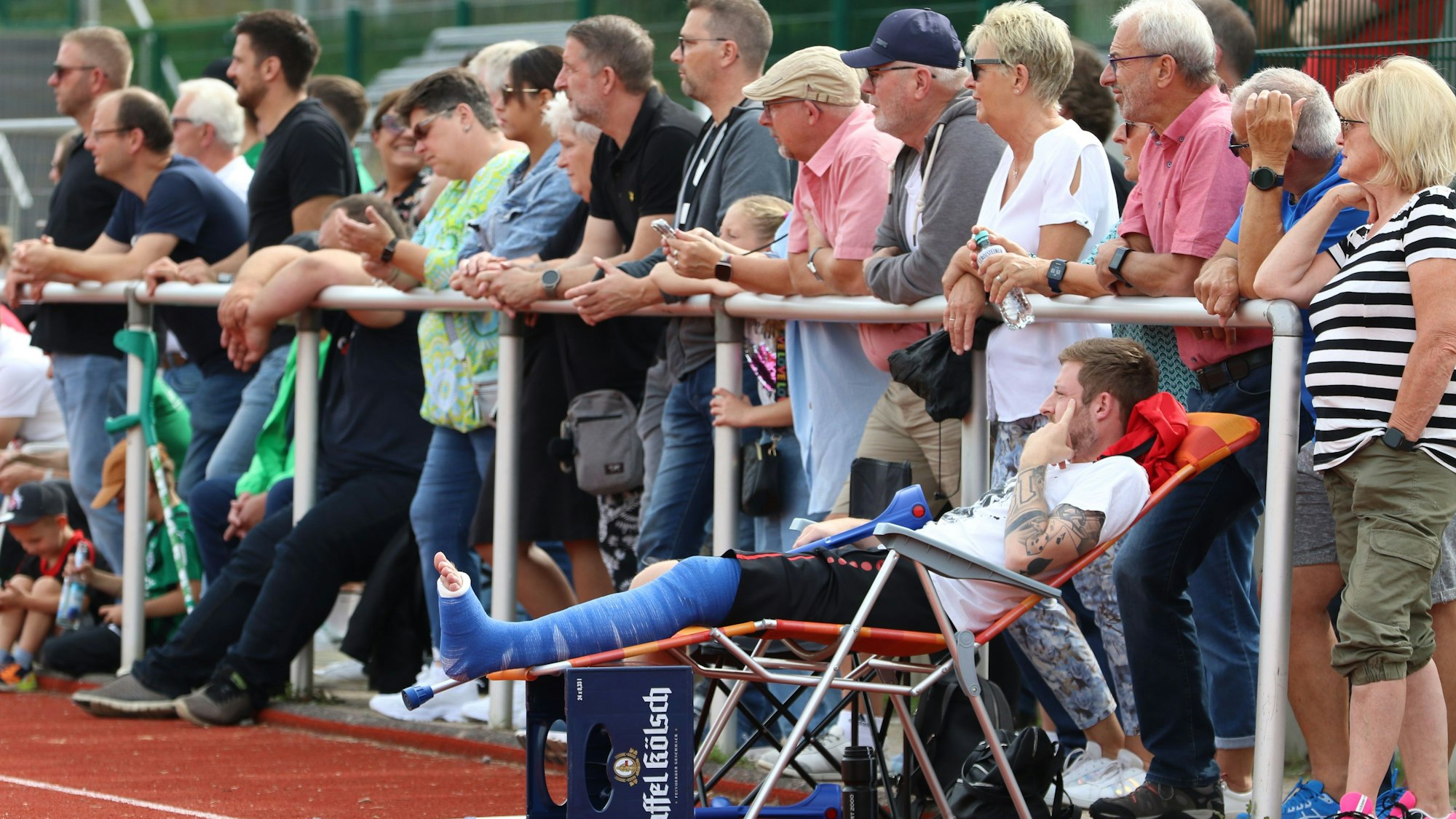 Ein verletzter Fußballer mit Gips hat es sich im Liegestuhl bequem gemacht.