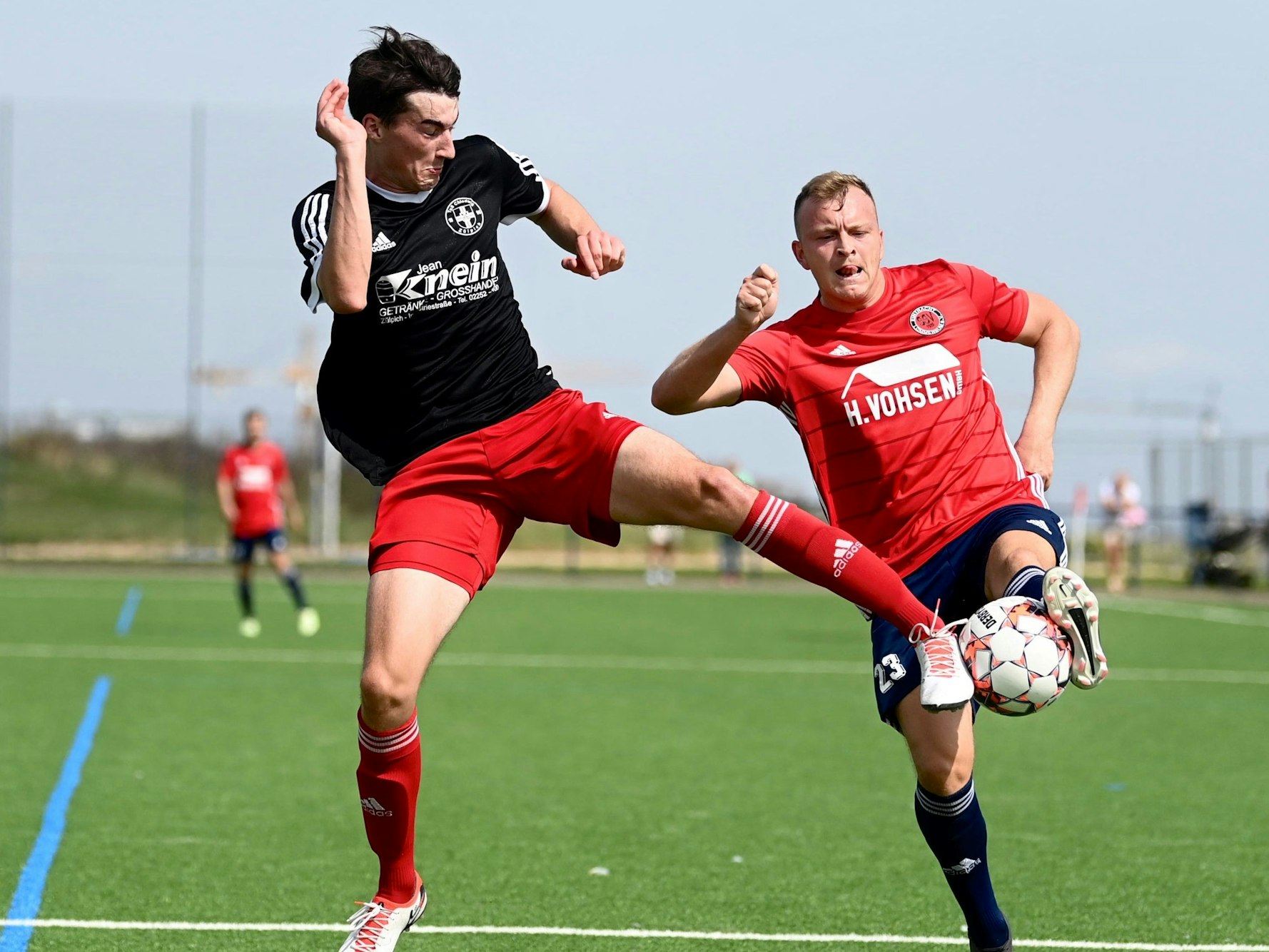 Zwei Fußballer im Pressschlag um den Ball.