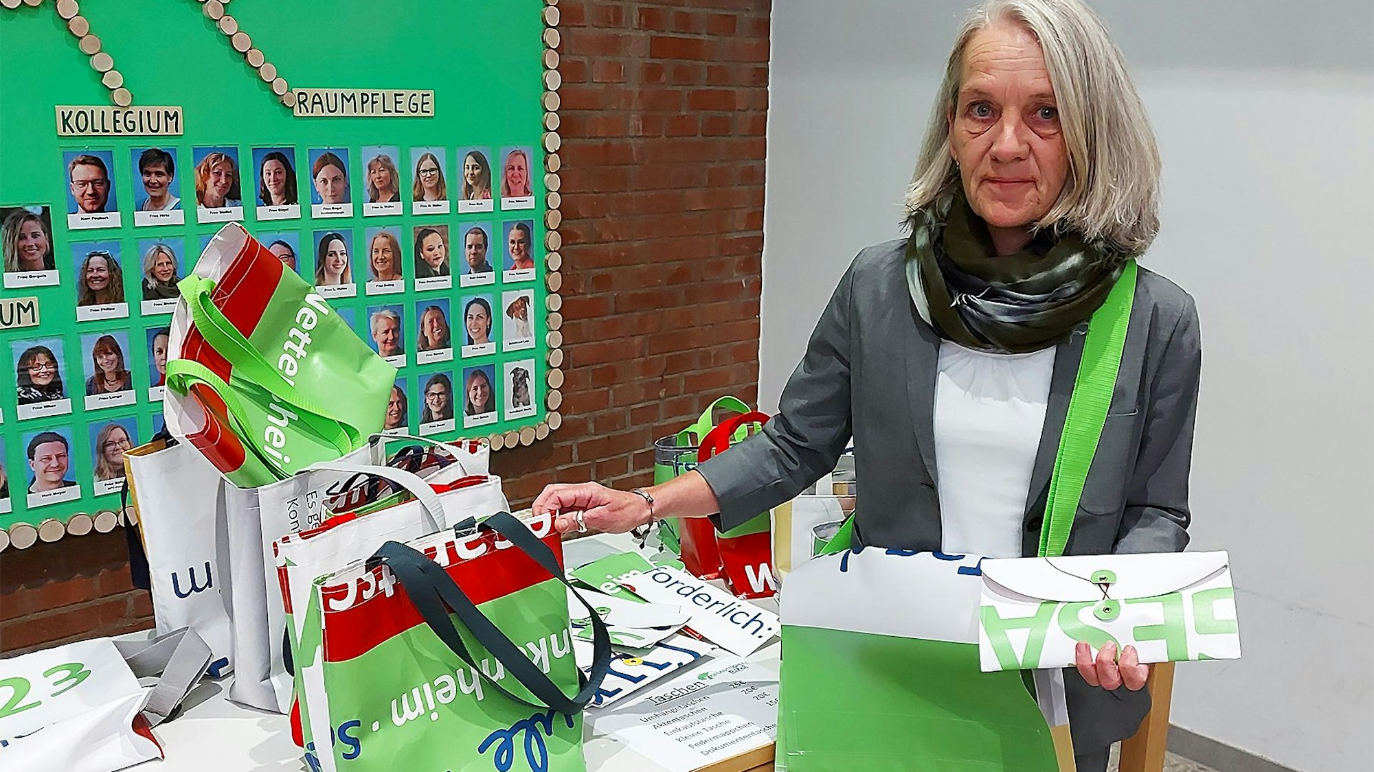 Elisabeth Weißkopf zeigt die umweltfreundlichen Artikel, die aus alten Plakaten der Gesamtschule Eifel hergestellt wurden.