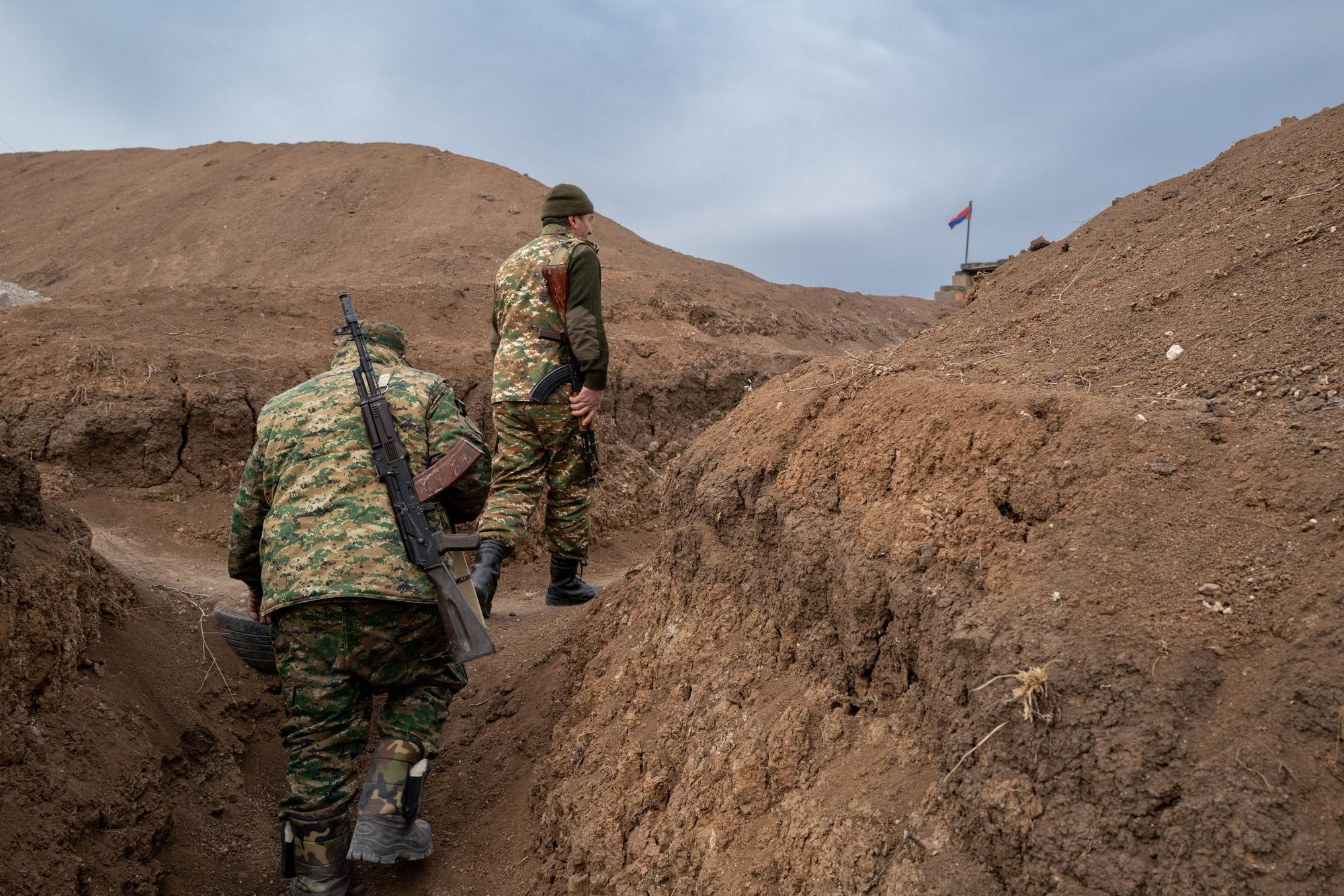 Armenien, Aravus: Zwei Soldaten gehen auf einem Militärposten an der Frontlinie im Latschin-Korridor, in der Nähe des Dorfes Aravus, entlang.