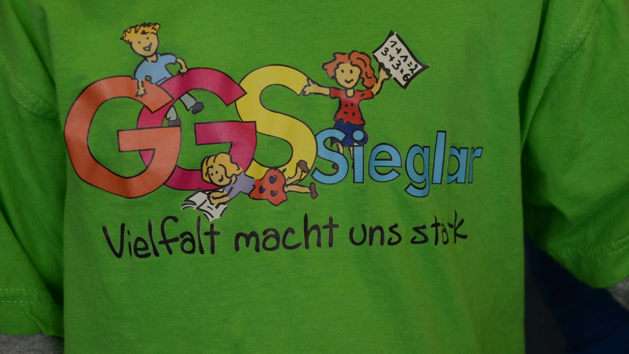 „Vielfalt macht uns stark“, steht als Motto auf einem grünen T-Shirt.