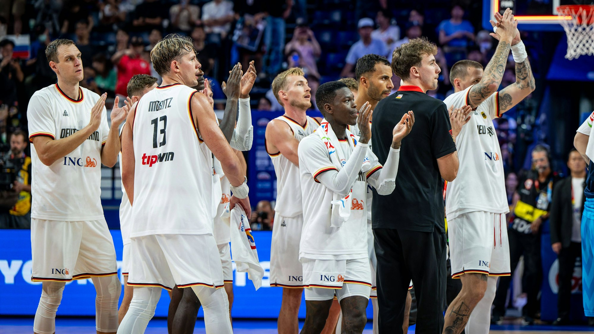 Die deutsche Basketball-Nationalmannschaft feiert mit dem Publikum nach dem Gruppensieg gegen Slowenien.