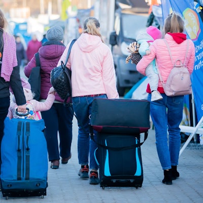 Das Bild zeigt Migrantinnen und ihre Kinder von hinten.