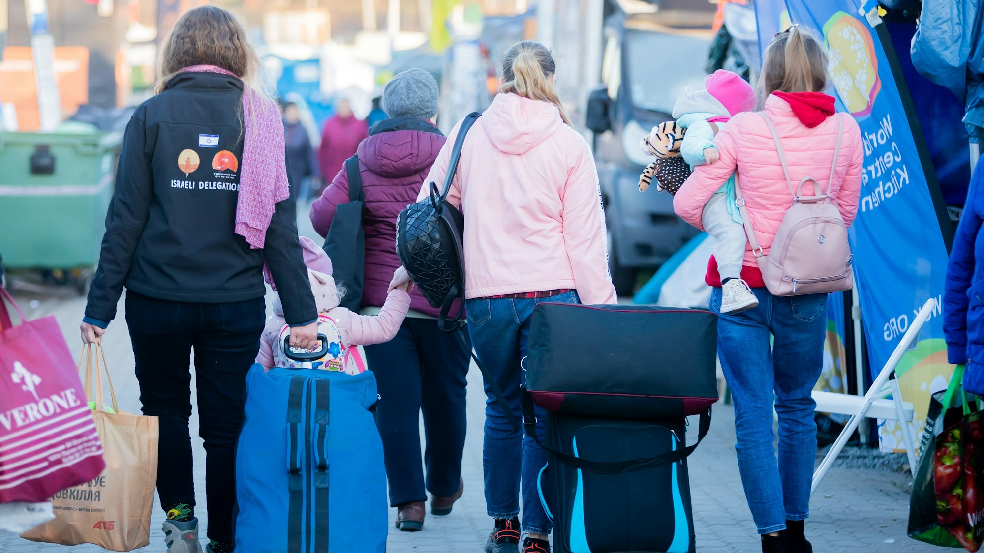 Das Bild zeigt Migrantinnen und ihre Kinder von hinten.