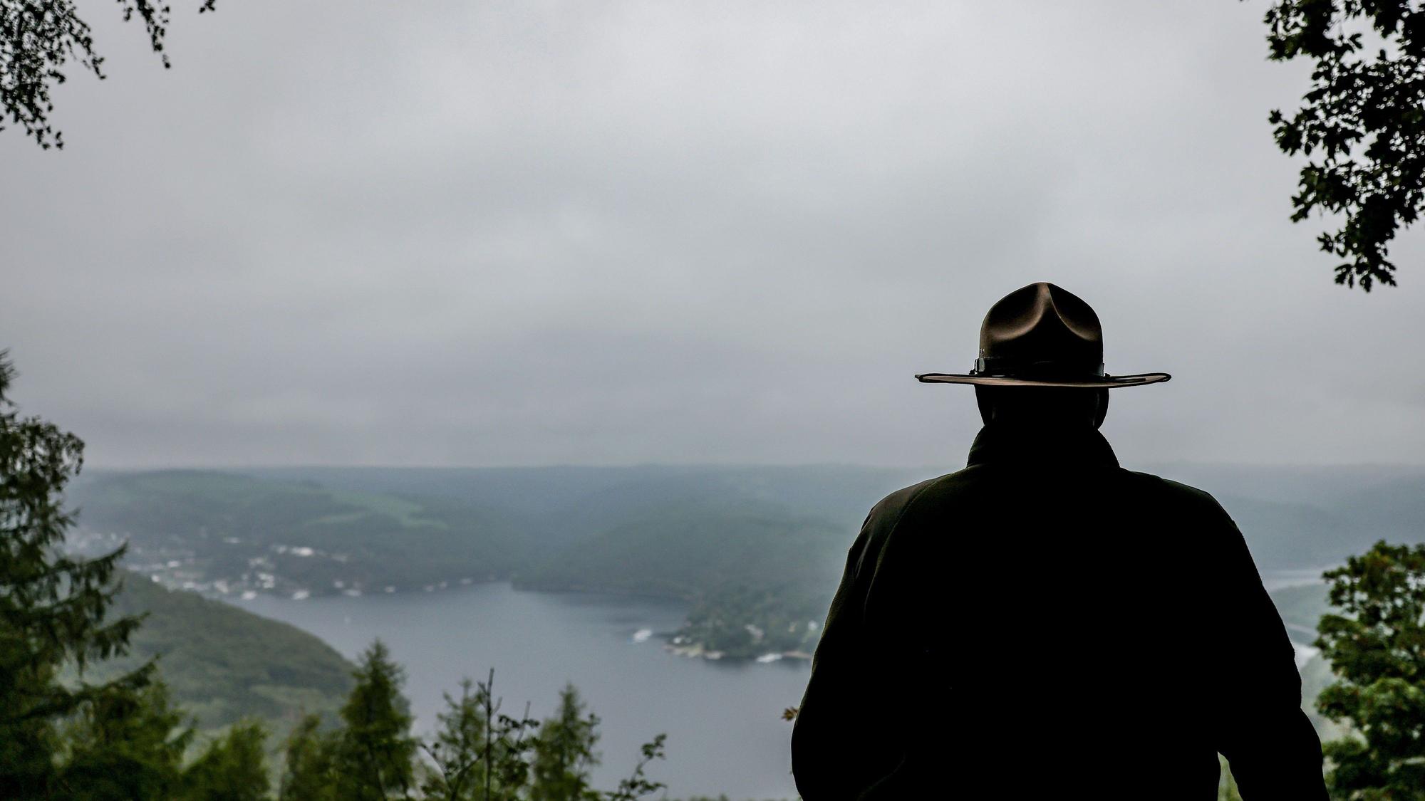 ARCHIV - 17.08.2023, Nordrhein-Westfalen, Gemünd: Ein Ranger steht im Nationalpark Eifel oberhalb des Urftsees an einer Lichtung. Für einen zweiten Nationalpark in Nordrhein-Westfalen will die Landesregierung das Beteiligungsverfahren starten. (zu dpa: «Verfahrensstart für zweiten Nationalpark in NRW») Foto: Oliver Berg/dpa +++ dpa-Bildfunk +++