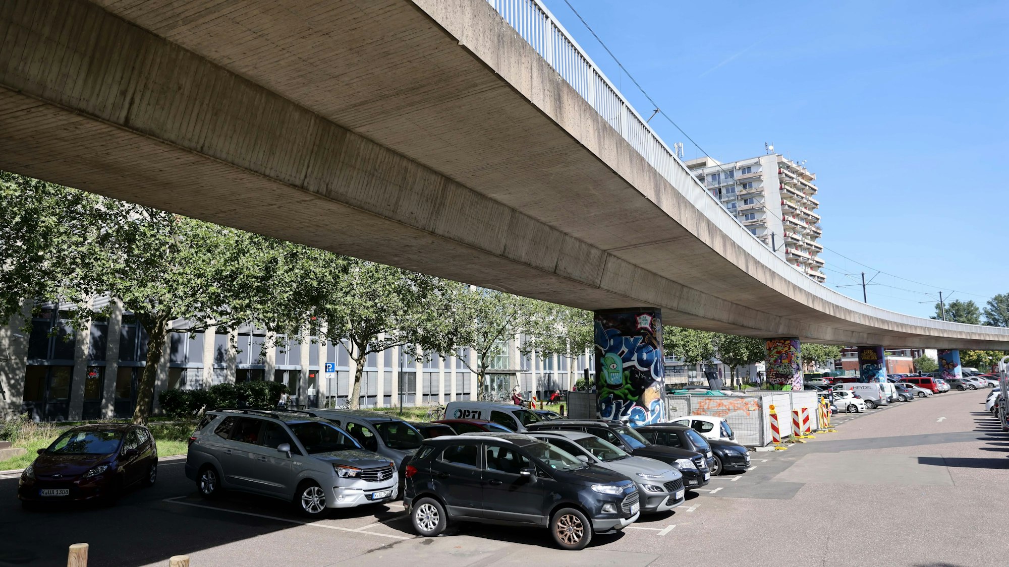 Autos parken unter der Hochbahn am Nippeser Bezirksrathaus.