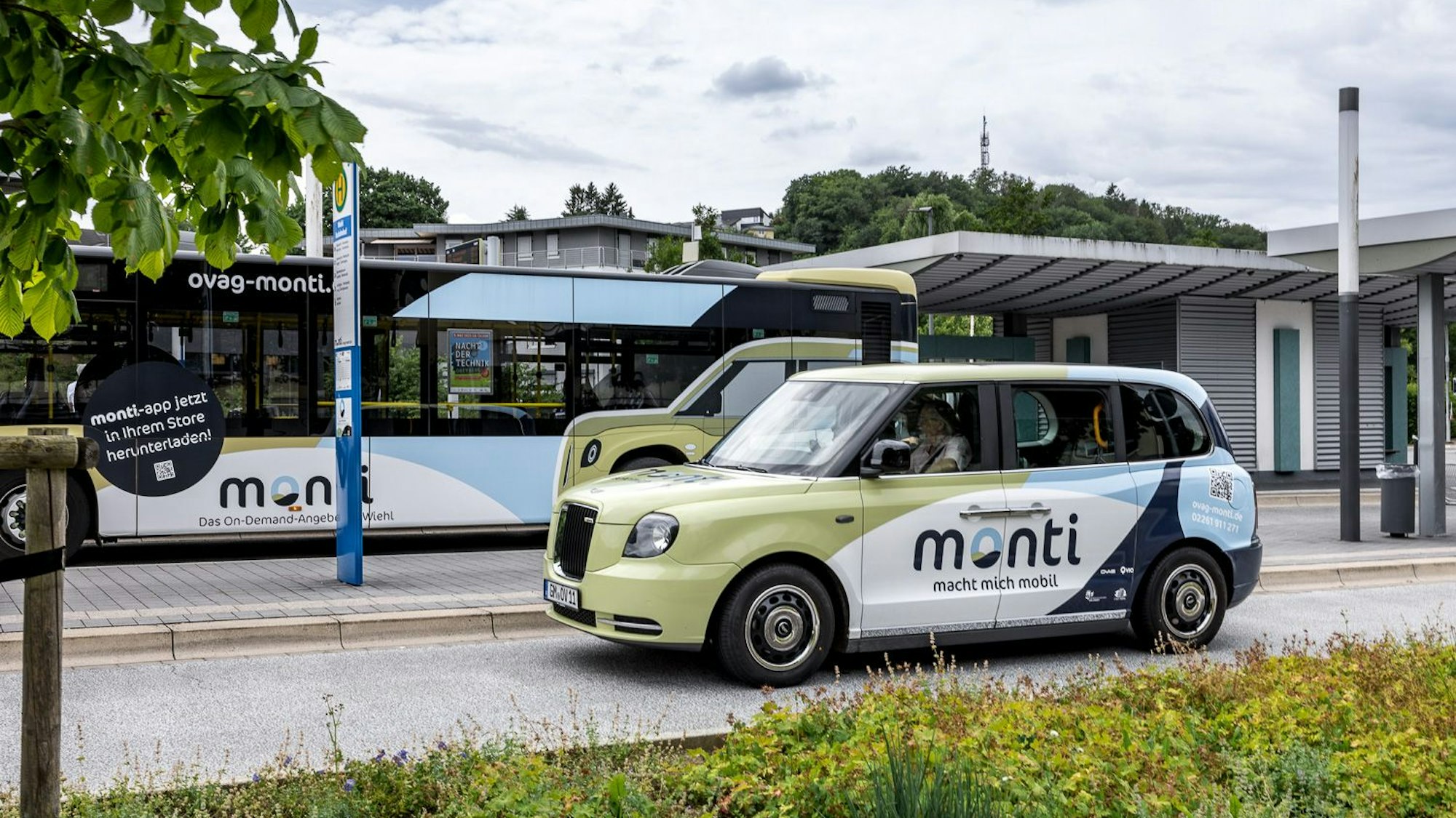 Ein Monti-Auto steht an einem Busbahnhof.