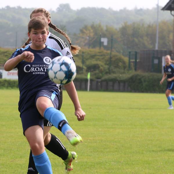 Eine Fußballerin schaut auf den Ball.