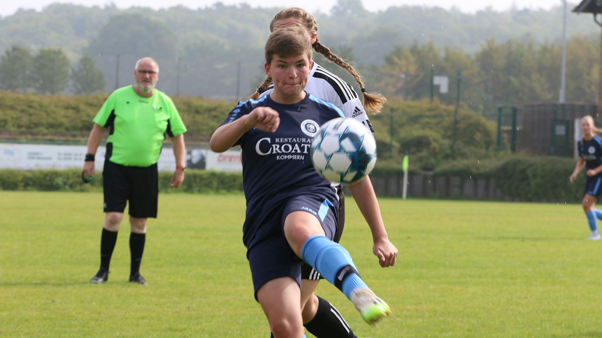 Eine Fußballerin schaut auf den Ball.
