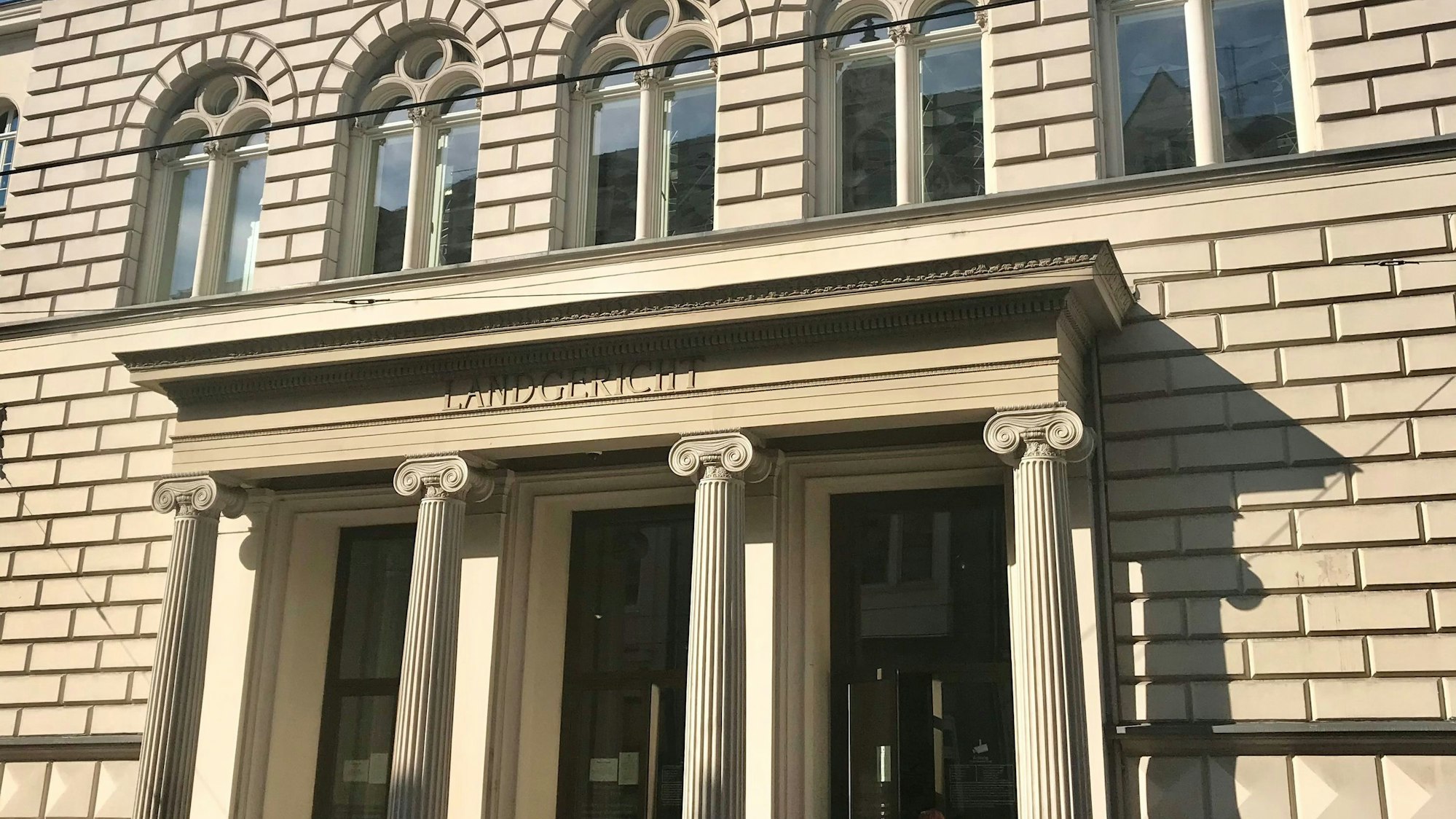 Ein heller Steinbau mit Säulenportal, auf dem das Wort „Landgericht“ steht.