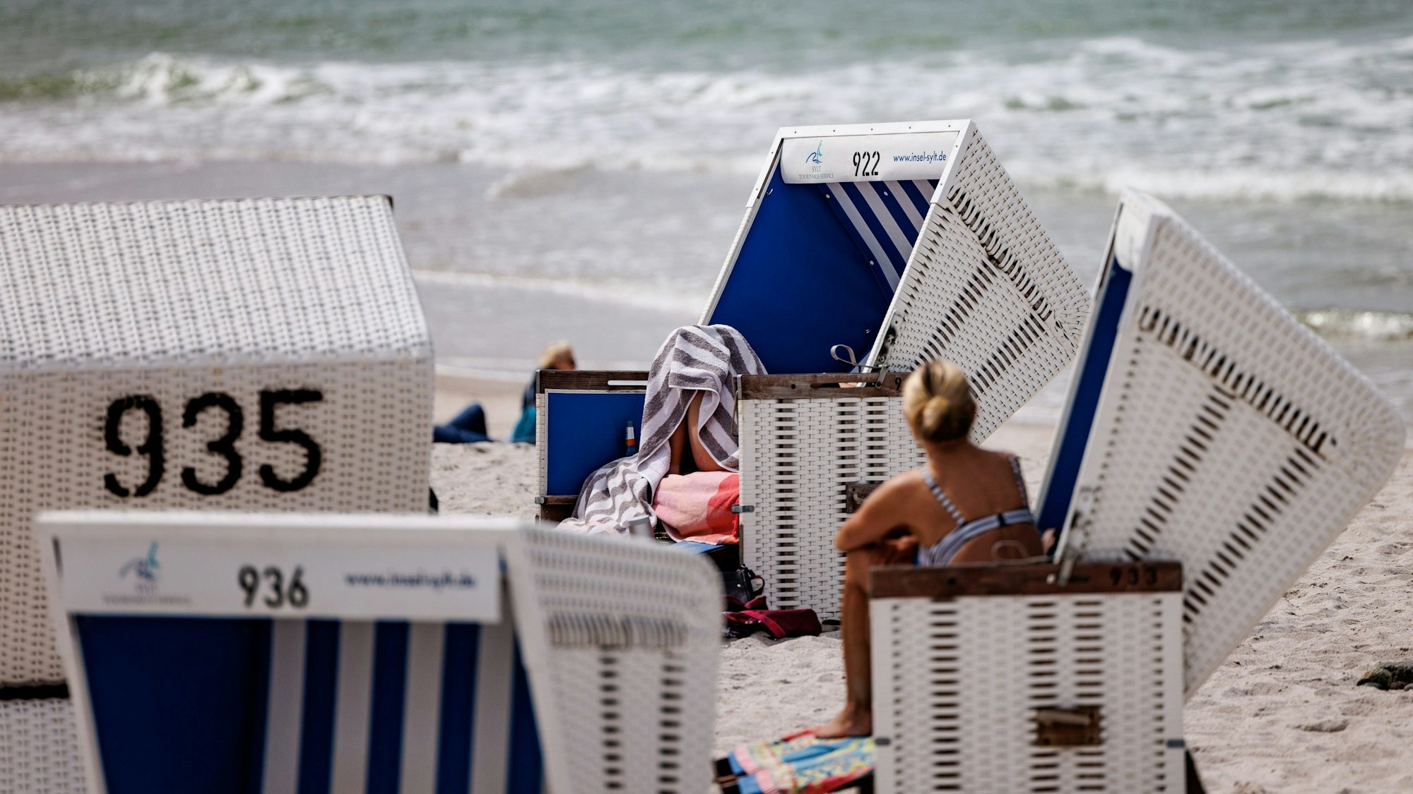 05.06.2022, Schleswig-Holstein, Westerland/Sylt: Besucher des Strands genießen die Sonne in Strandkörben. Durch die Einführung des 9-Euro-Tickets haben sich die traditionell hohen Touristenzahlen an Pfingsten noch einmal erhöht. Foto: Axel Heimken/dpa +++ dpa-Bildfunk +++