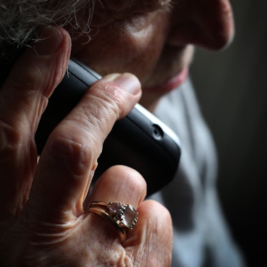 Eine ältere Frau telefoniert mit einem schnurlosen Festnetztelefon.