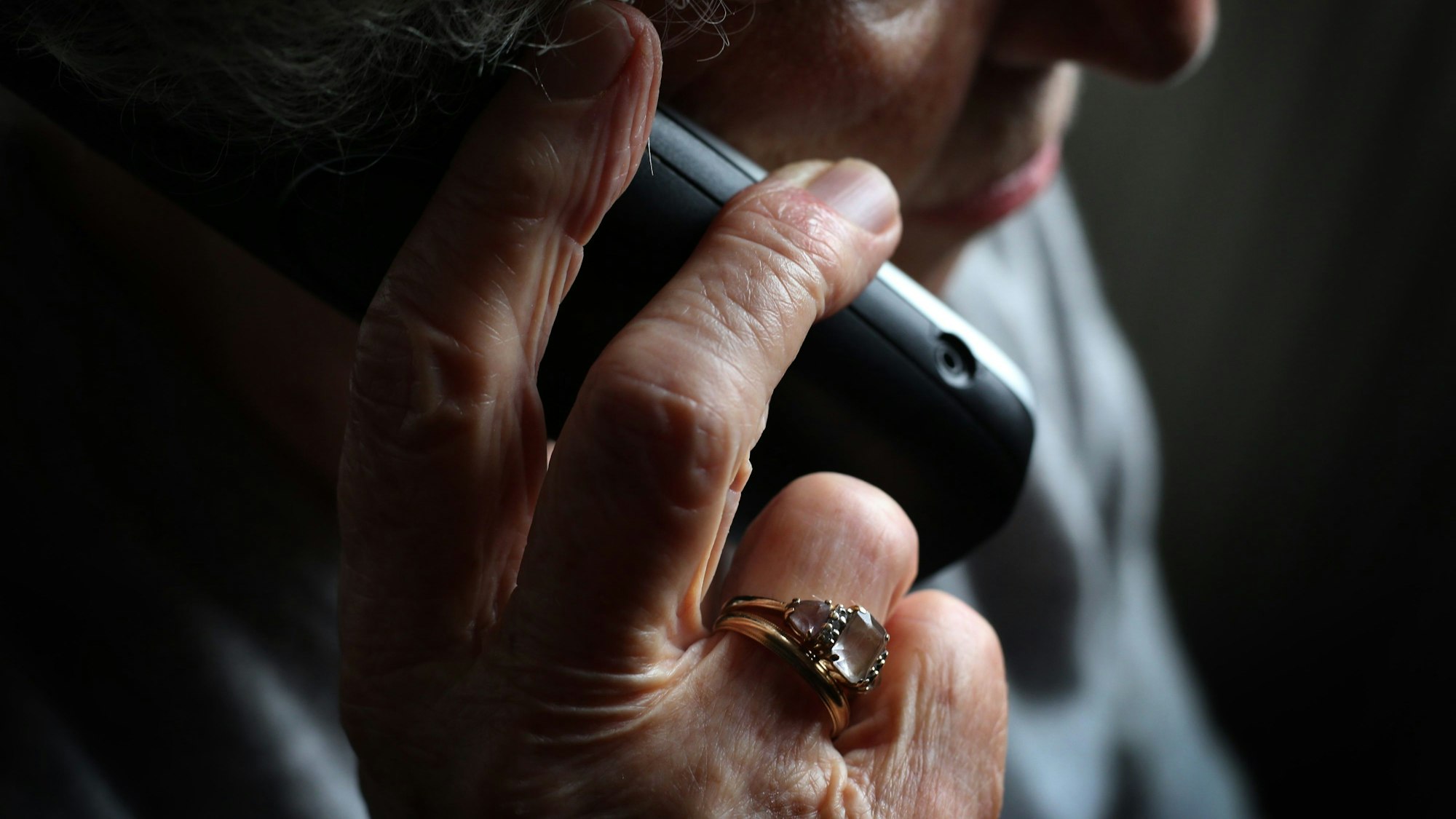 Eine ältere Frau telefoniert mit einem schnurlosen Festnetztelefon.