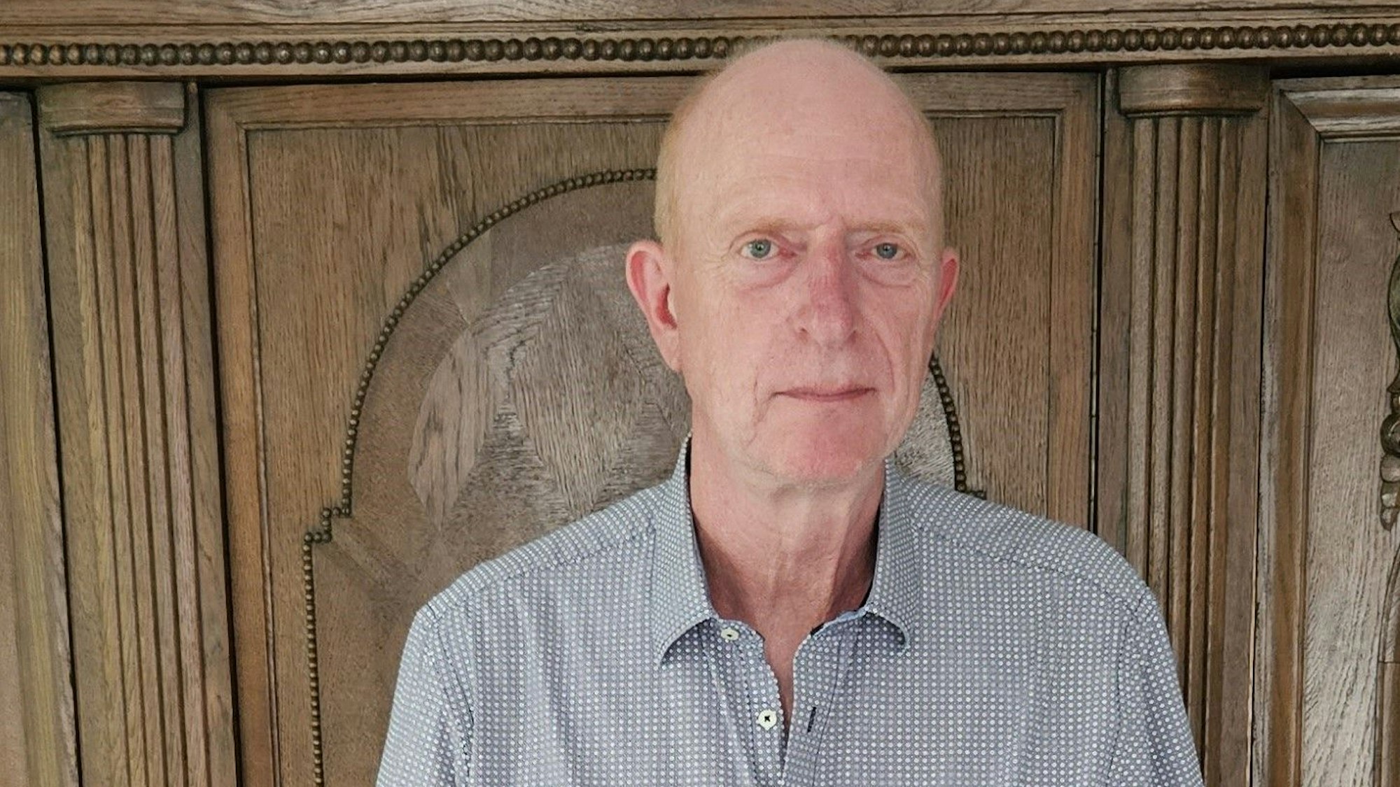 Richard Fremerey steht vor einem alten Schrank.