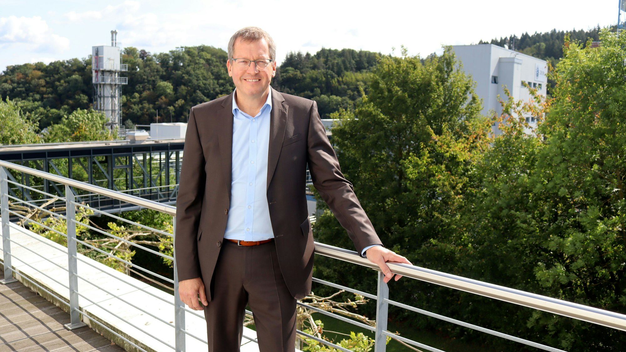 Peter Greven, im Hintergrund das Unternehmen.