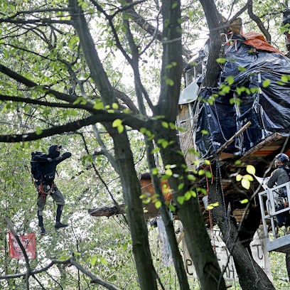 17.09.2018, Nordrhein-Westfalen, Kerpen: Polizisten nähern sich in einem Hubwagen einem Baumhaus.