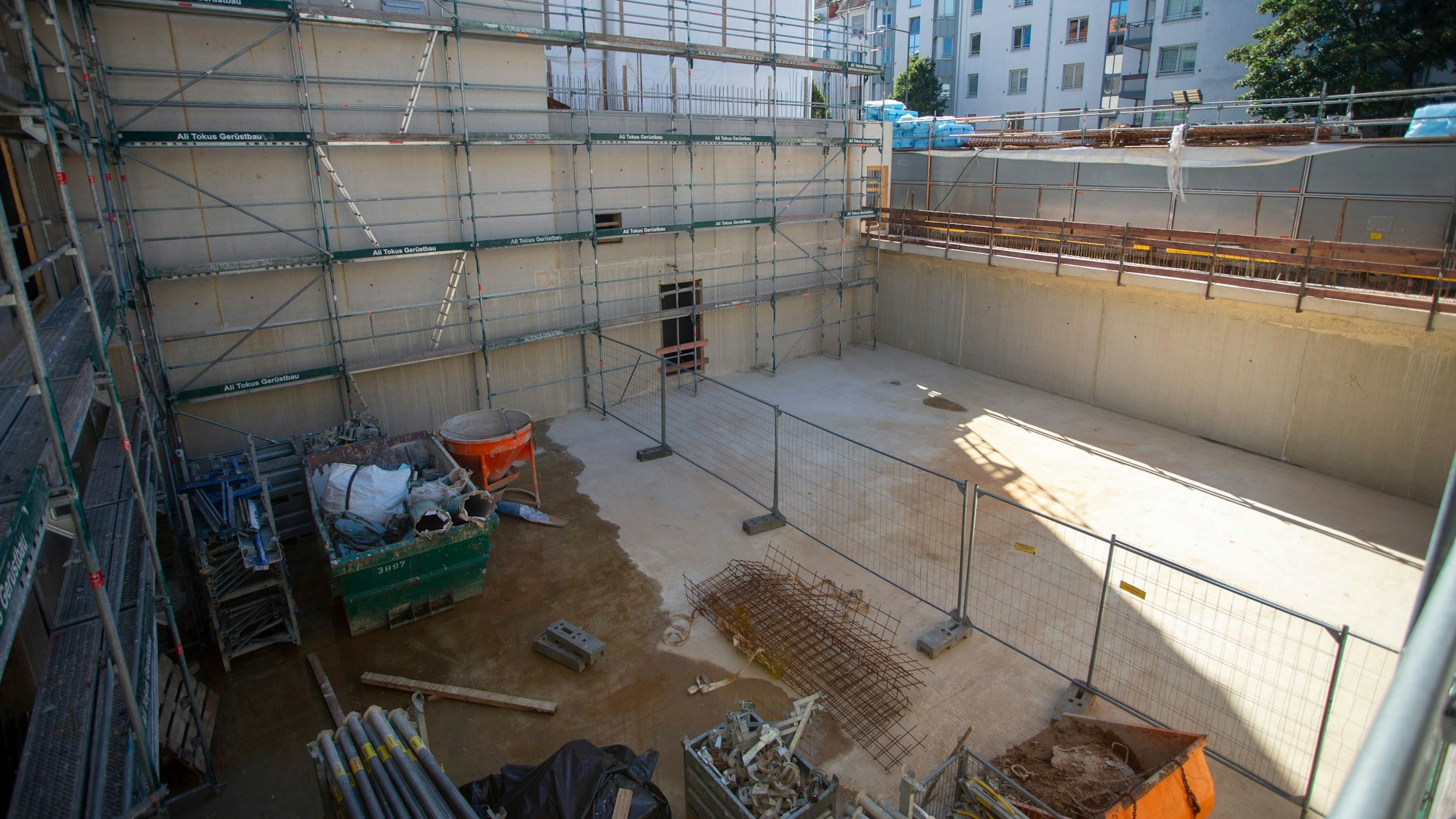 Der Keller eines neuen Gebäudes an der Vogelsanger Straße mit Werkzeugen und Rohren. Ein Dach gibt es noch nicht.