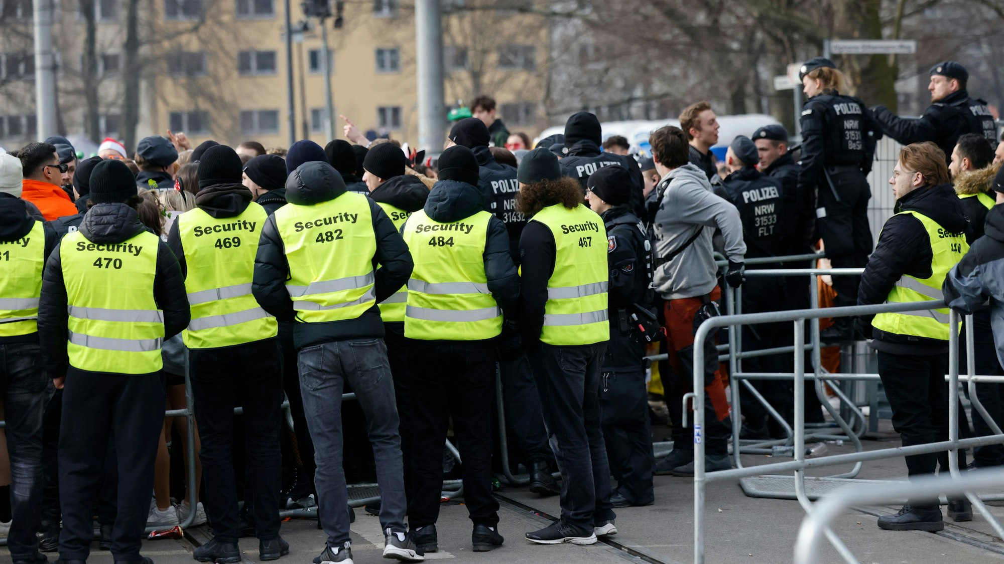 Mitarbeiter einer Sicherheitsfirma stehen beim Straßenkarneval im Februar 2022 an einer Absperrung im Zülpicher Viertel.
