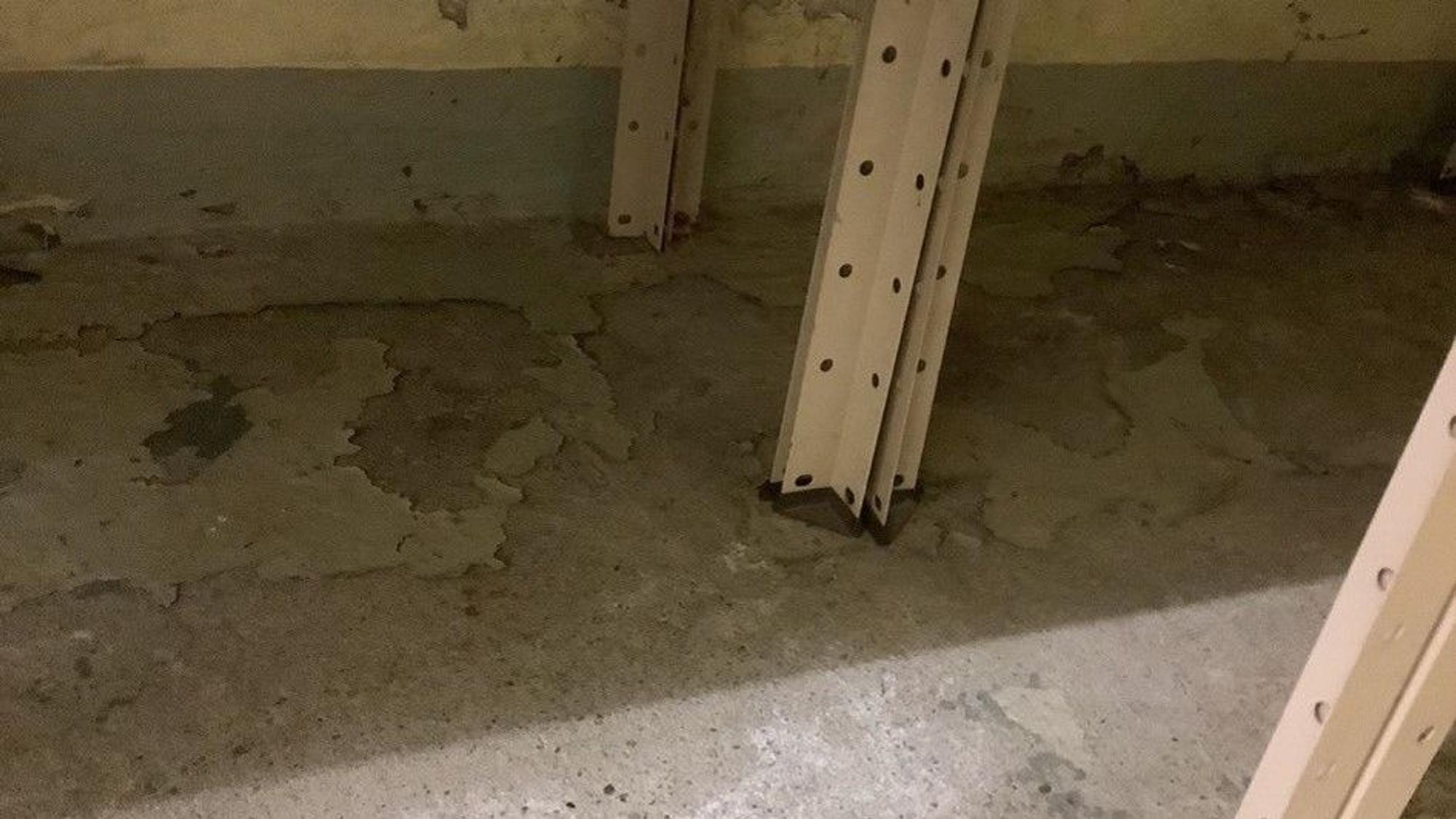 Ein grauer Boden hat feuchte und wellige Stellen.