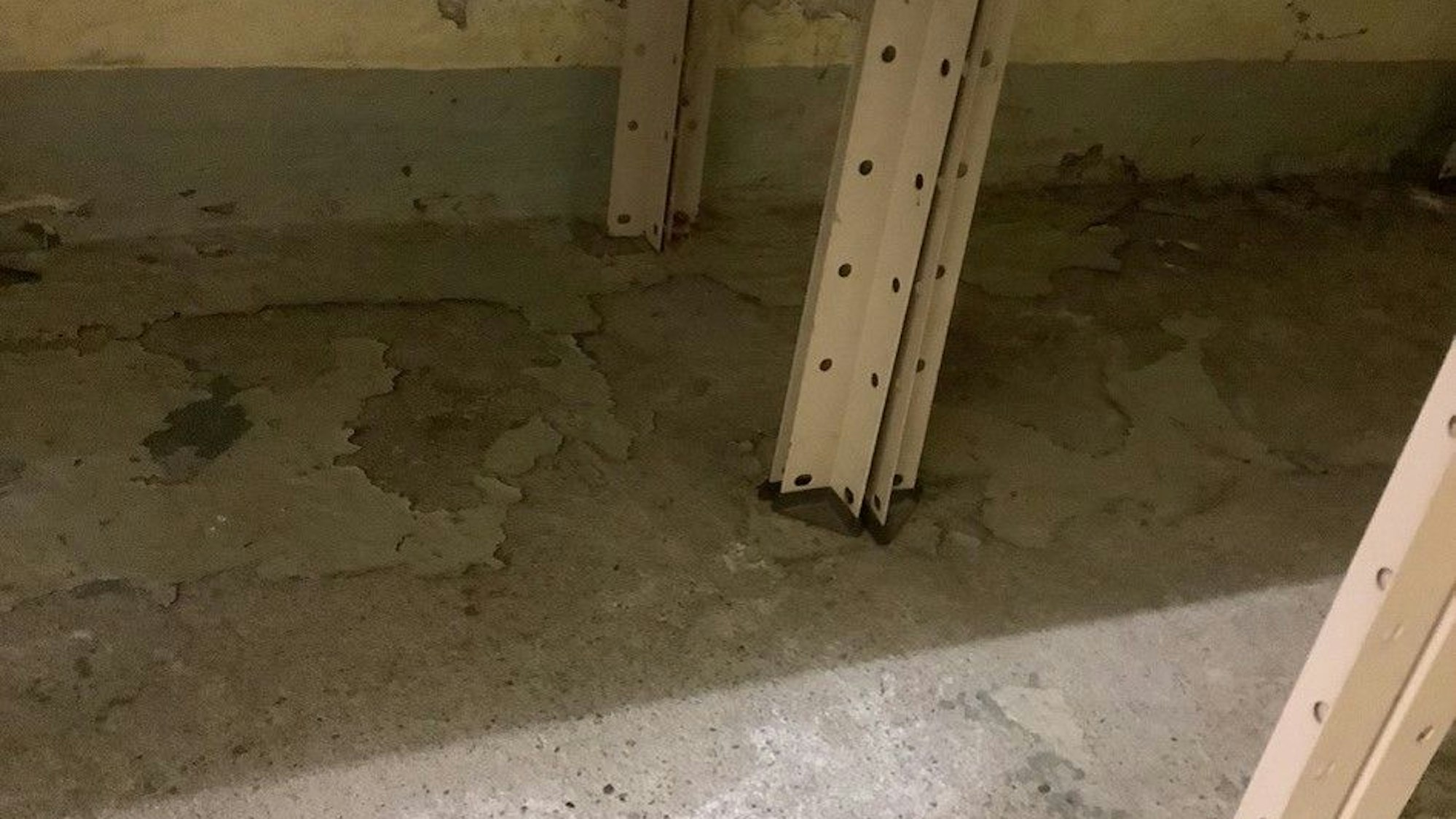 Ein grauer Boden hat feuchte und wellige Stellen.