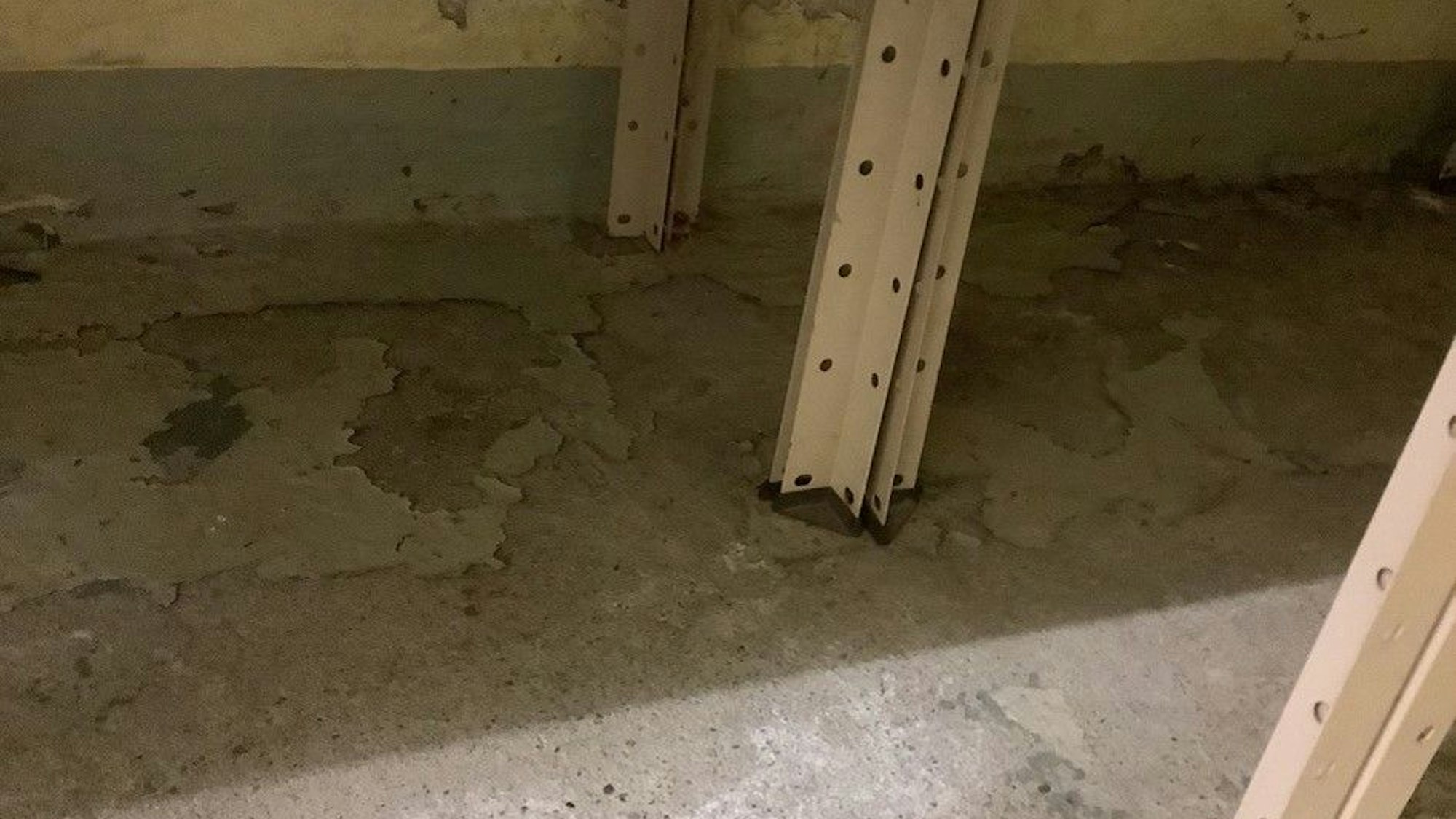 Ein grauer Boden hat feuchte und wellige Stellen.