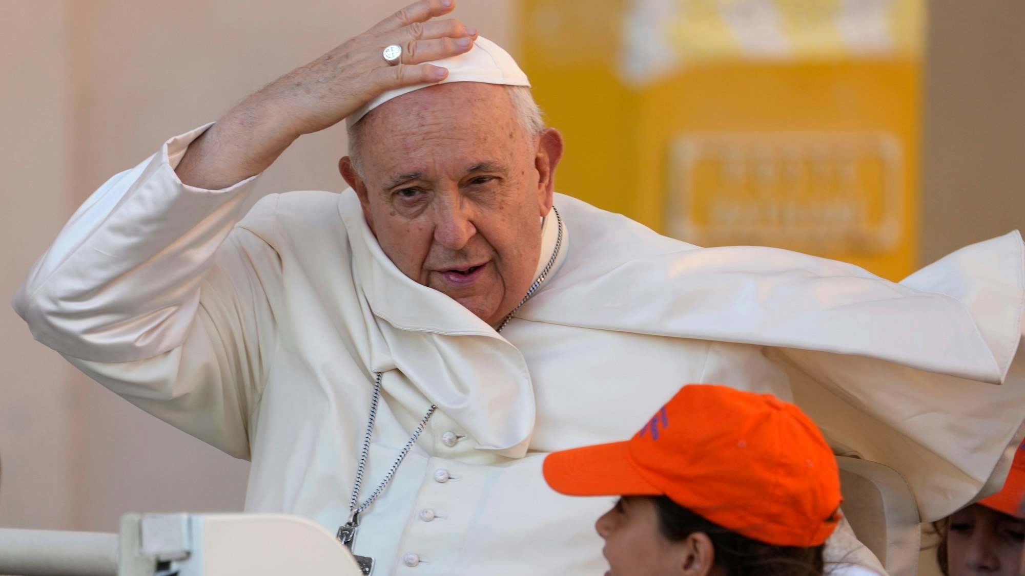 Vatikan, Vatikanstadt: Papst Franziskus kommt zu seiner wöchentlichen Generalaudienz auf dem Petersplatz und hält seine Kappe fest.