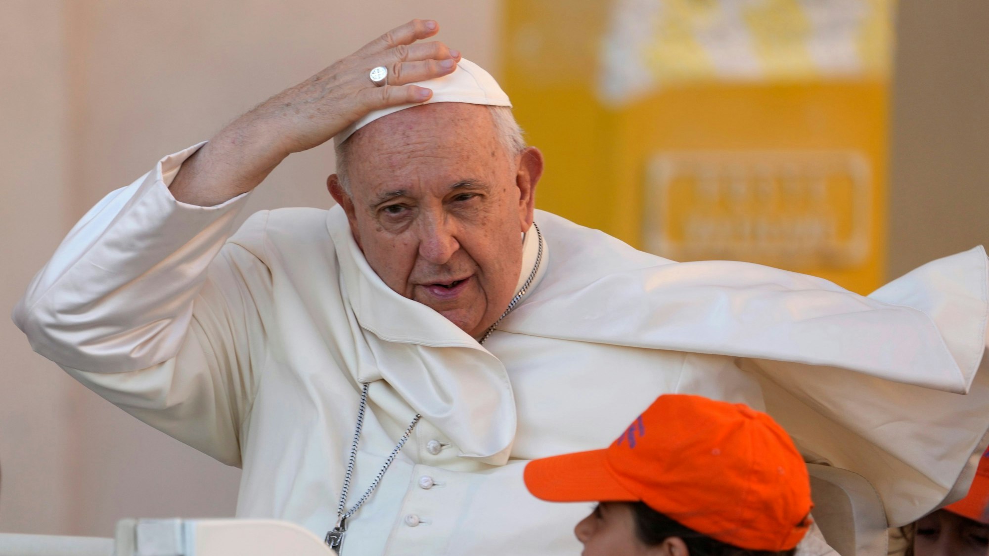 06.09.2023, Vatikan, Vatikanstadt: Papst Franziskus kommt zu seiner wöchentlichen Generalaudienz auf dem Petersplatz und hält seine Kappe fest.