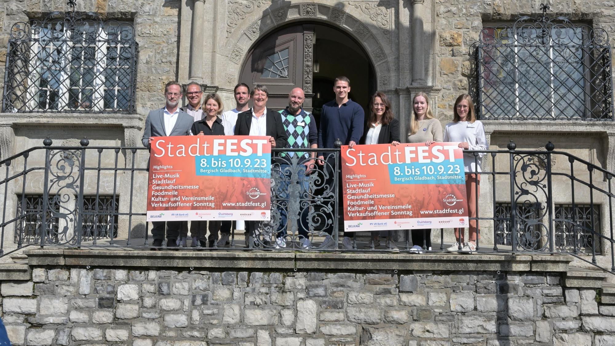Das Foto zeigt die Organisatoren des Gladbacher Stadtfestes an der Rathaustreppe.
