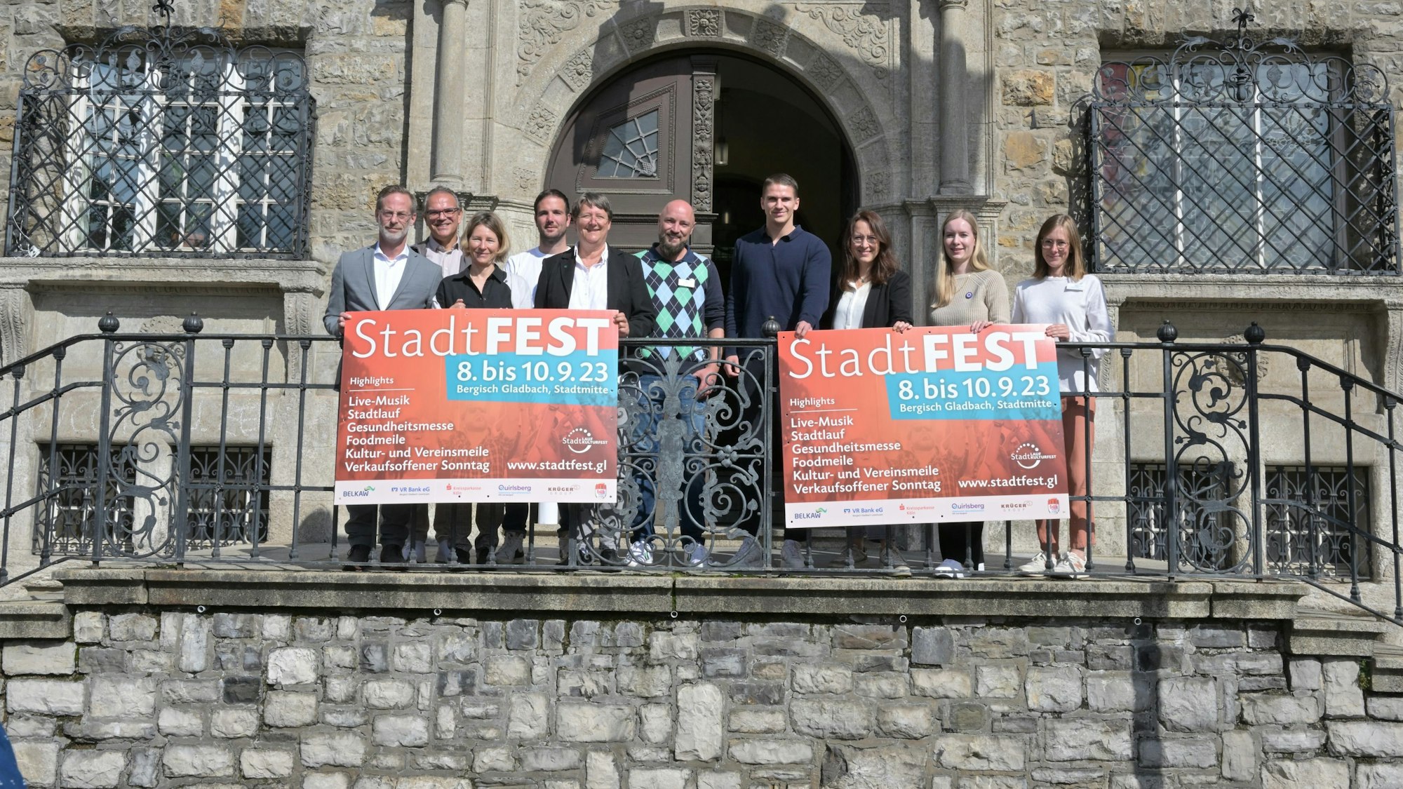 Das Foto zeigt die Organisatoren des Gladbacher Stadtfestes an der Rathaustreppe.
