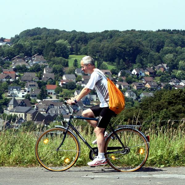 Das Foto zeigt einen Radfahrer auf einer Straße oberhalb von Kürten