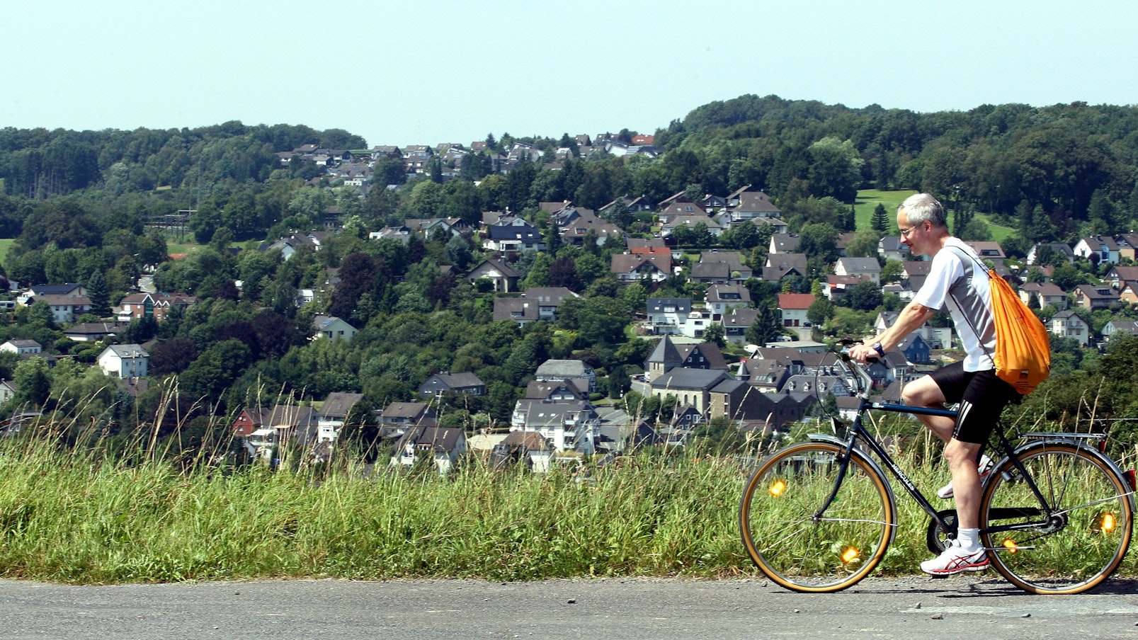 Das Foto zeigt einen Radfahrer auf einer Straße oberhalb von Kürten