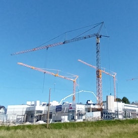 Baustelle mit vier Kränen und Funkturm im Hintergrund