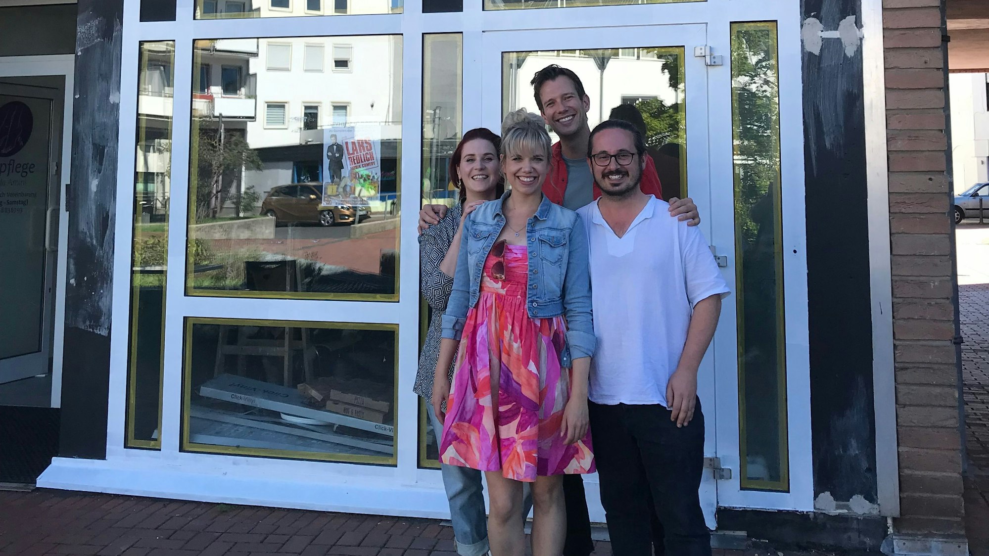 Vier Personen stehen vor dem Theater.