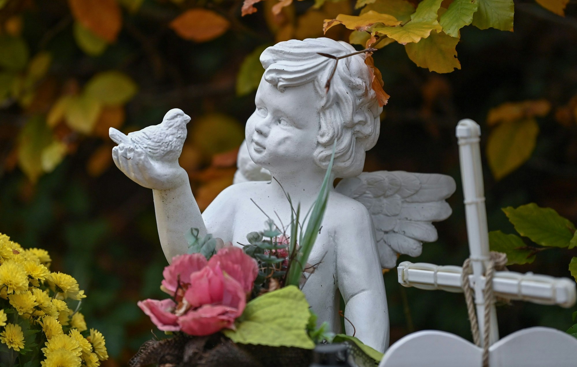 Das Foto zeigt eine kleine Engelfigur auf einem Friedhof