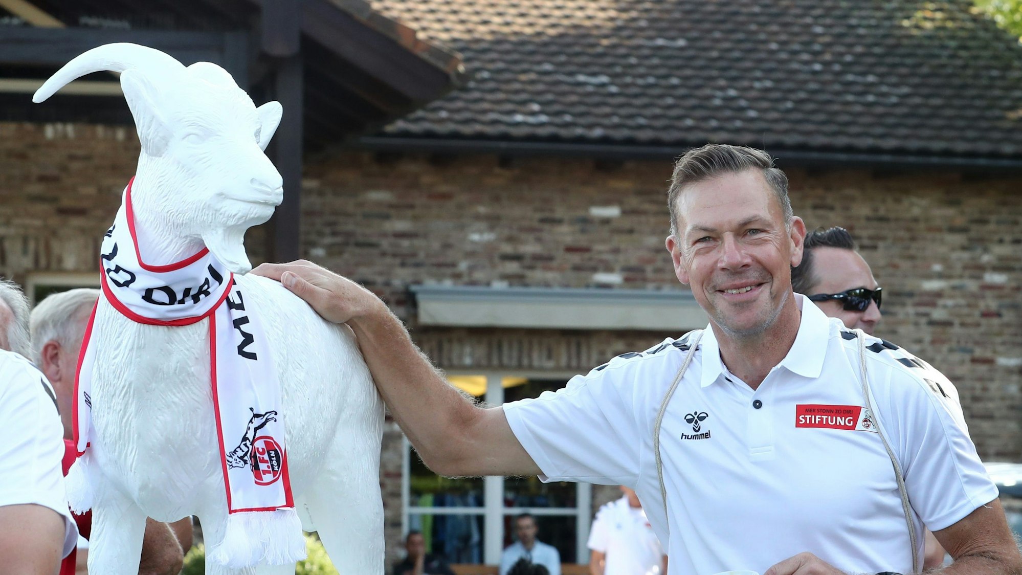 Das Bild zeigt Ex-Fußballprofi Erik Meijer neben dem Geißbock.