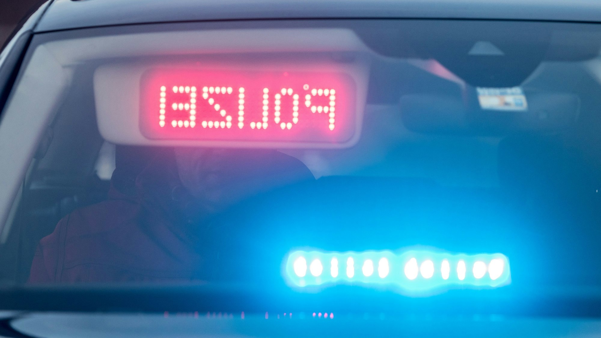 Ein Warndisplay mit der Spiegelschrift „Polizei“ ist hinter der deutsch-tschechischen Grenze an der Sonnenblende in einem Zivilfahrzeug der Polizei angebracht.
