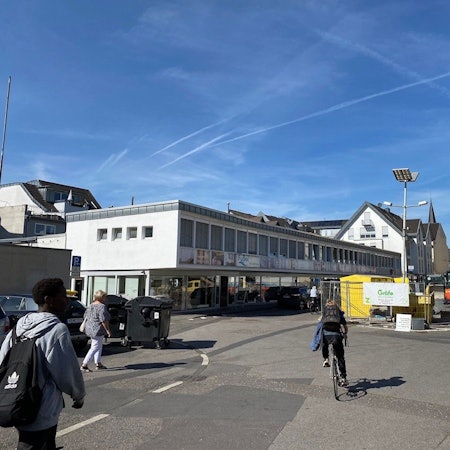 Zu sehen ist der Platz, auf dem Baumaschinen und -material lagert. Im Hintergrund ist der Rathausneubau zu erkennen.