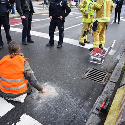 ARCHIV - 06.01.2023, Baden-Württemberg, Mannheim: Ein Aktivist der Gruppierung Letzte Generation sitzt mit einer angeklebten Hand auf der Straße.     (zu dpa «Weitere Entwicklung nach dem umstrittenen Vorgehen der Polizei in Mannheim gegen Klimaaktivisten») Foto: René Priebe/dpa +++ dpa-Bildfunk +++