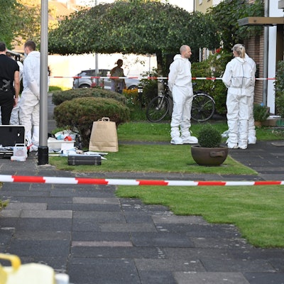 Mitarbeiterinnen und Mitarbeiter der Spurensicherung stehen vor dem Haus des getöteten Rentners.