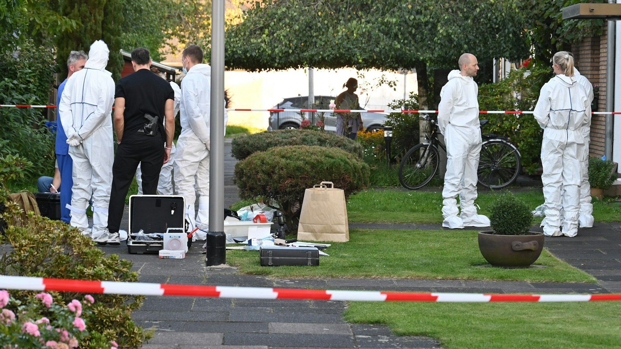 Mitarbeiterinnen und Mitarbeiter der Spurensicherung stehen vor dem Haus des getöteten Rentners.