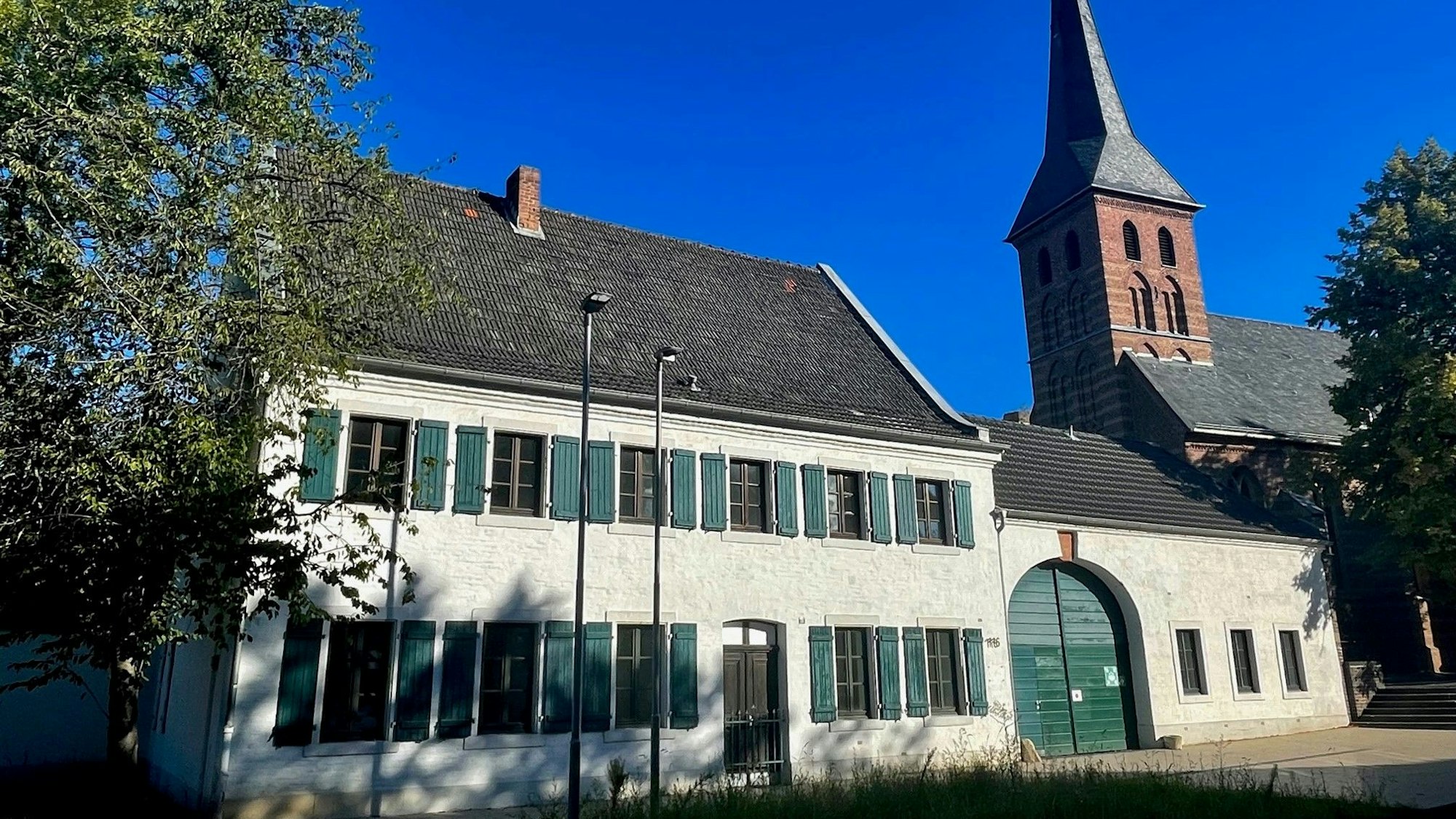 Das Foto zeigt den denkmalgeschützten Fronhof neben der Liblarer Pfarrkirche St. Alban.