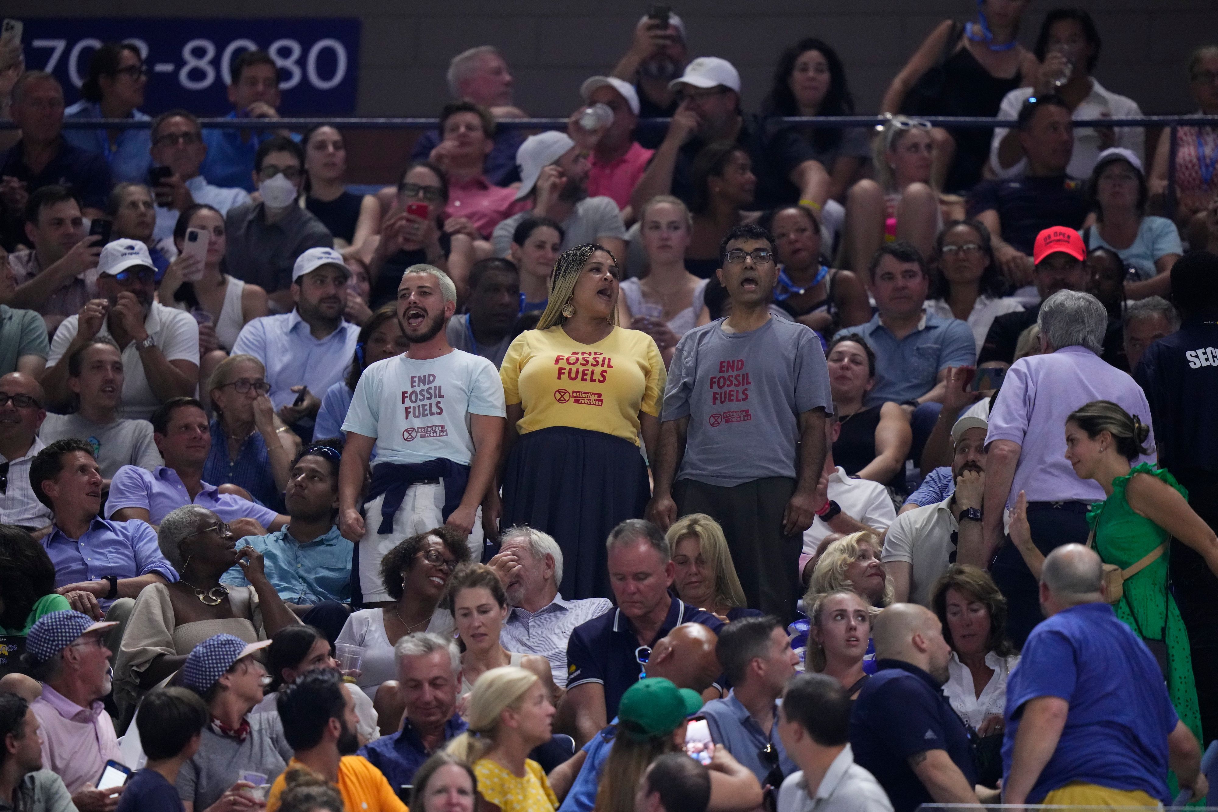Protesters demonstrate at a match between Coco Gauff, of the United States, and Karolina Muchova, of the Czech Republic, during the women's singles semifinals of the U.S. Open tennis championships, Thursday, Sept. 7, 2023, in New York. (AP Photo/Frank Franklin II)