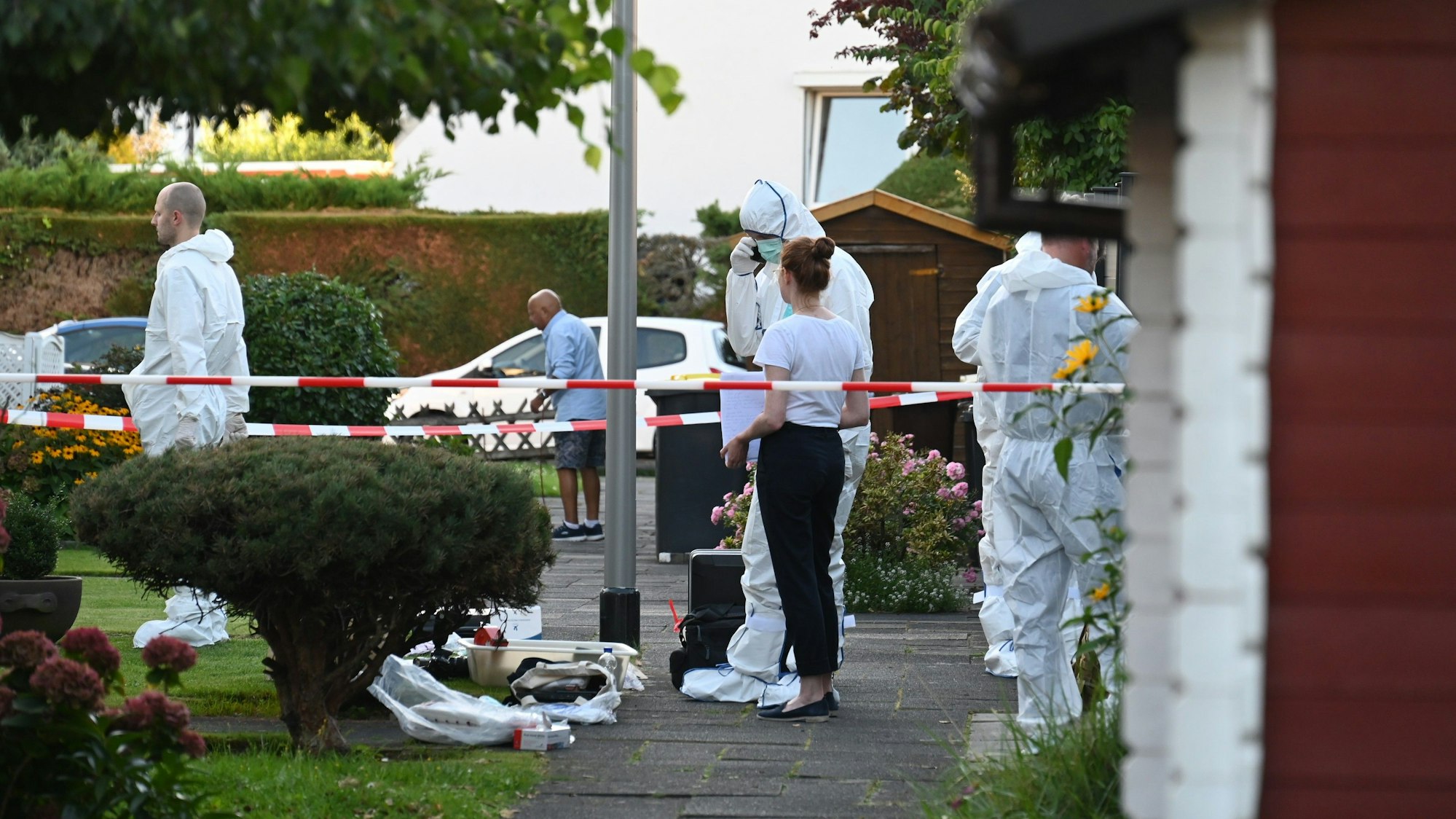Das Bild zeigt Kripobeamte in weißen Schutzanzügen vor dem Haus des Rentners.