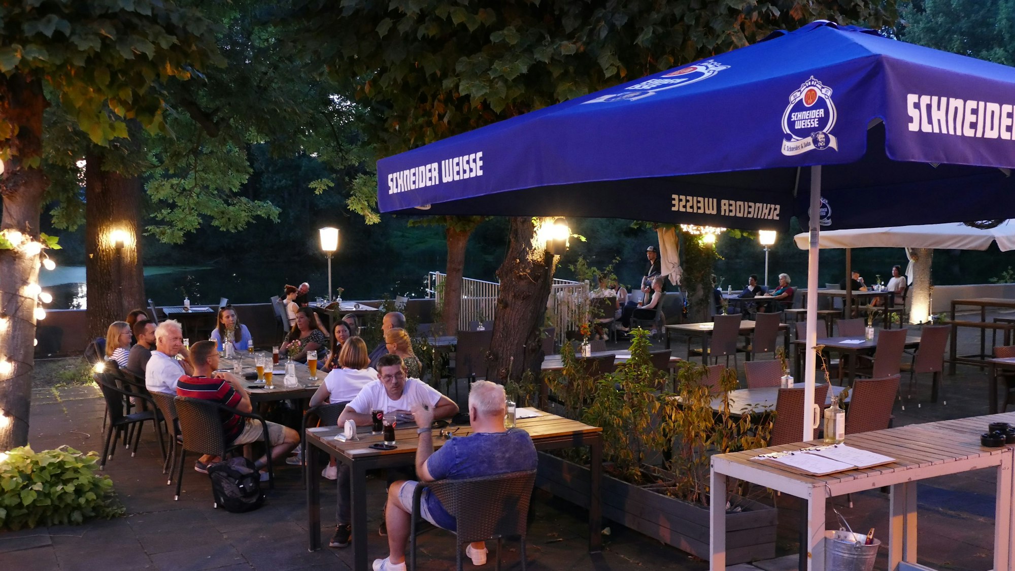 Ein blauer Schirm auf einer Terrasse.