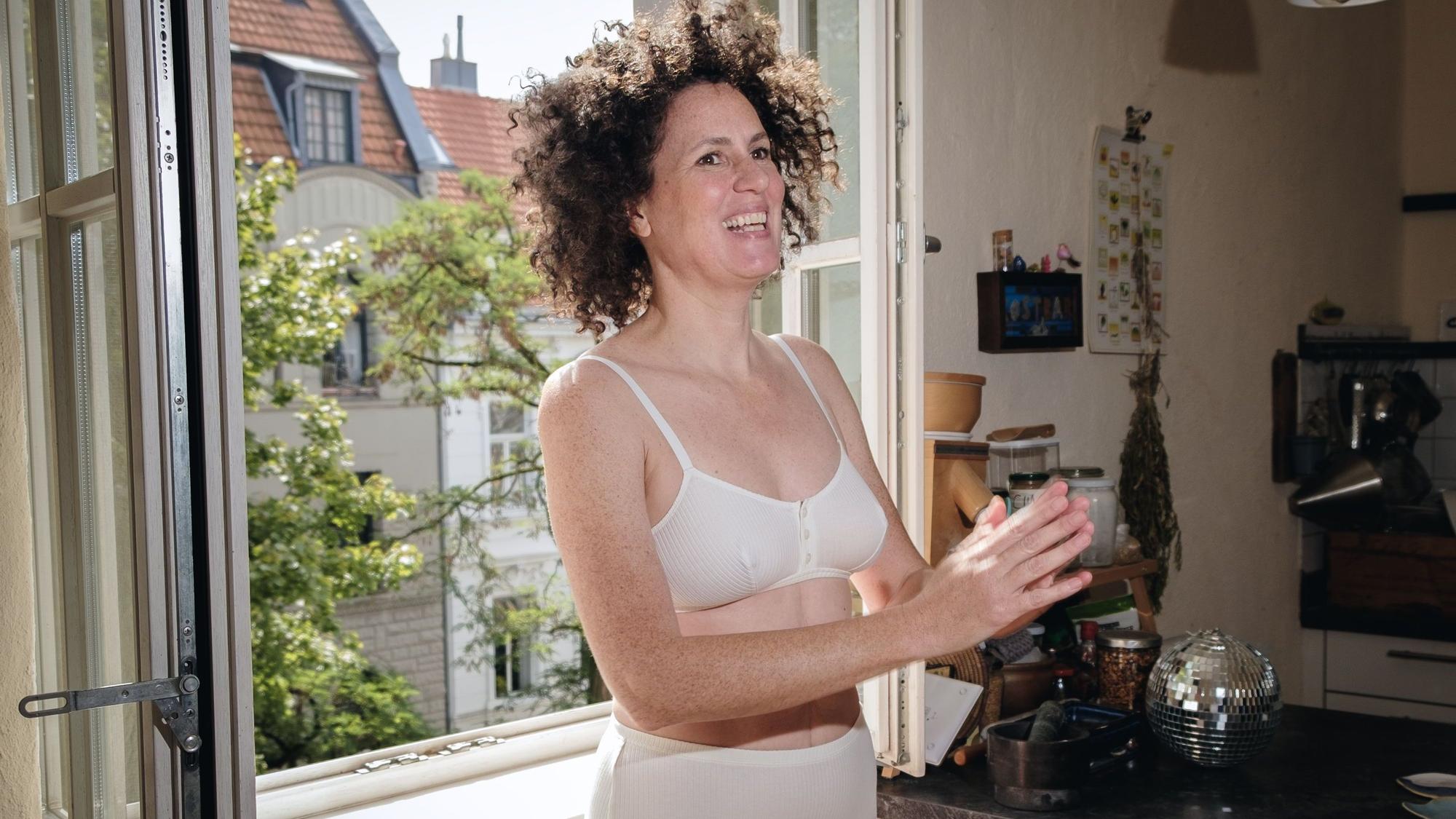 Frau trägt ein weißes Bralette aus Biobaumwolle.