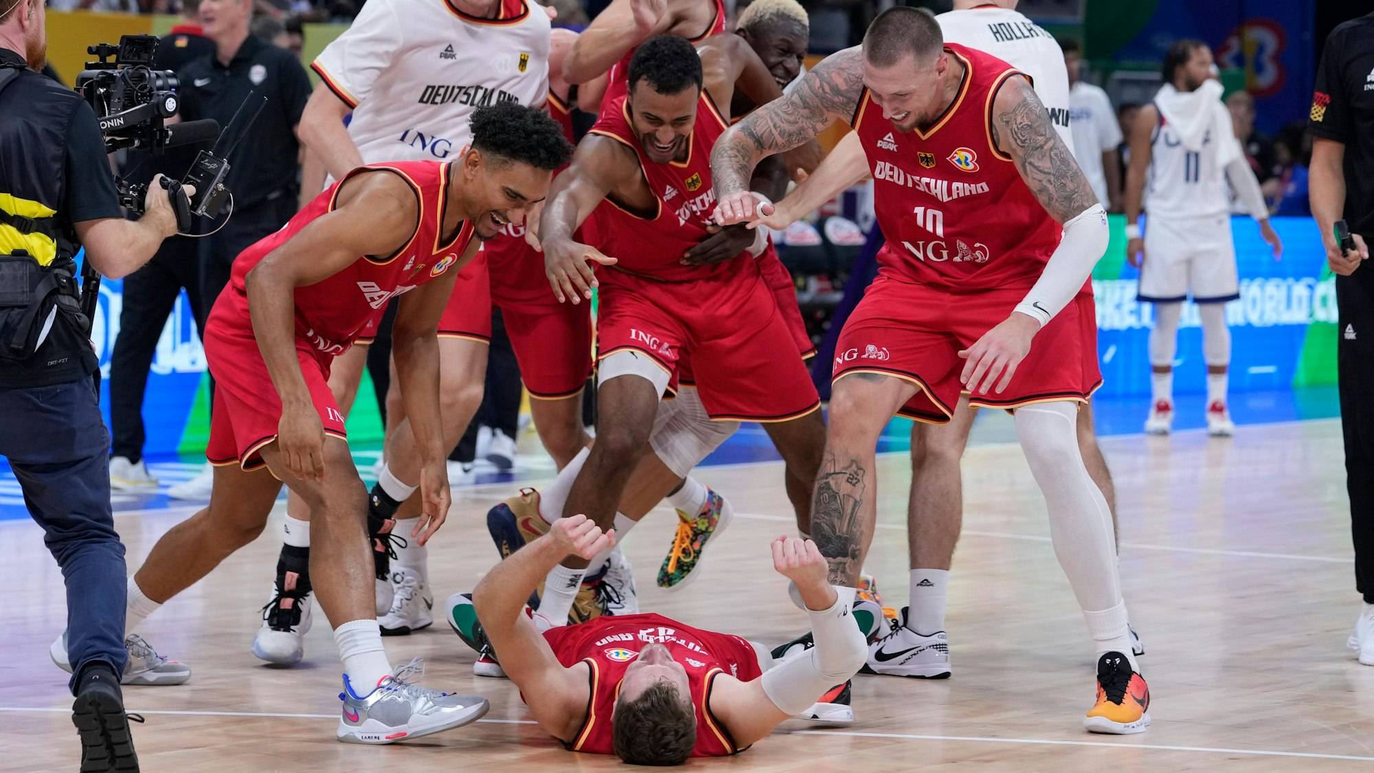 Andreas Obst liegt auf dem Boden, seine Teamkollegen feiern ihn und den Halbfinal-Sieg gegen die USA.