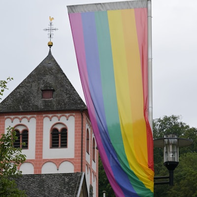 Regenbogenflagge vor einem Kirchturm in Odenthal.