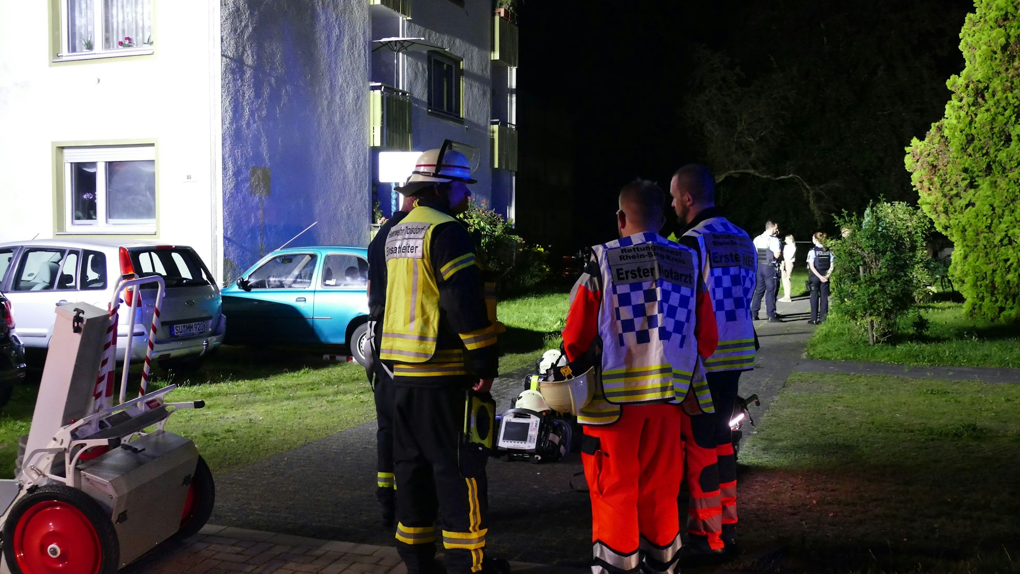 Einsatzkräfte stehen vor dem Haus in der Kurt-Schumacher-Straße.