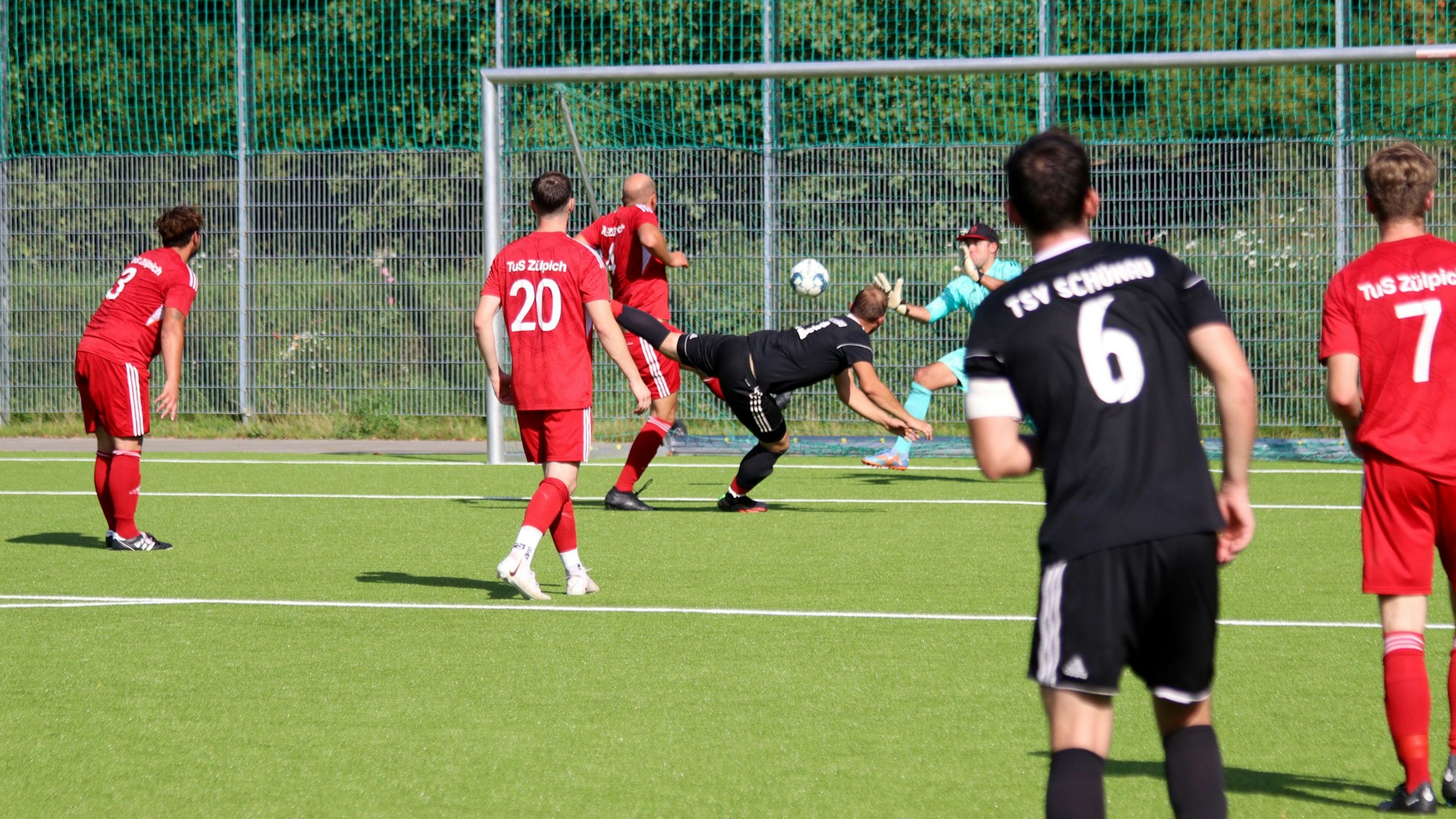 Ein Fußballspieler erzielt ein Tor mit dem Kopf.