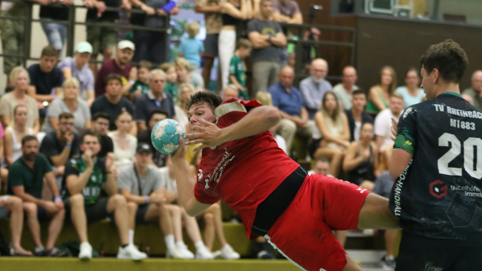 Ein Handballspieler liegt fast quer in der Luft.
